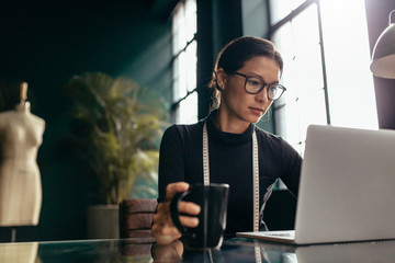 Female dress designer using laptop