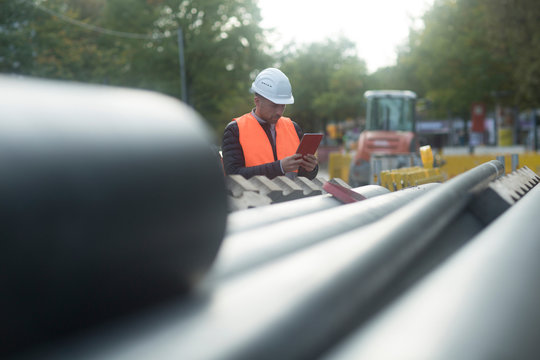 Road engineer standing by pipes