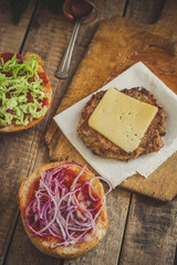 Burger with chop, cheese, onion and tomato sauce