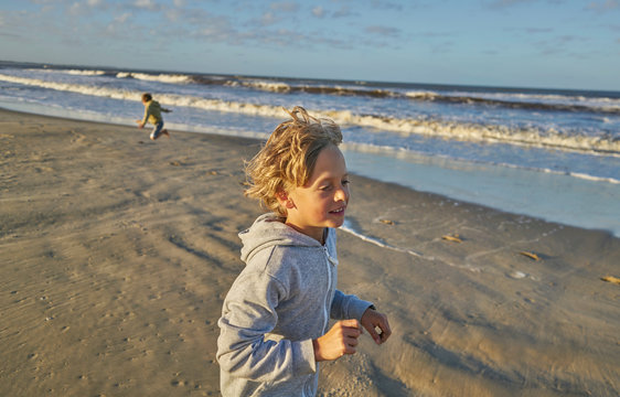 Boy in beach playing in lapping waves, Polonio, Rocha, Uruguay, South America