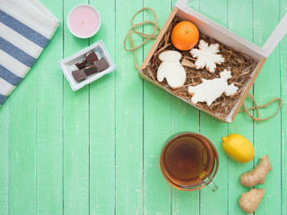 Glass cup of black tea, chocolate and gingerbread gingerbread on a mint-colored table