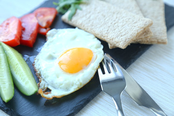 Breakfast with fried egg and fresh vegetables