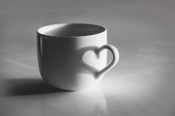 Heart shaped shadow on a coffee cup, black and white