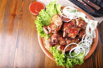 Pieces of meat with onions on skewers kebab . Top view