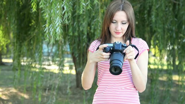 Beautiful woman tourist goes and takes photos using DSLR photo camera