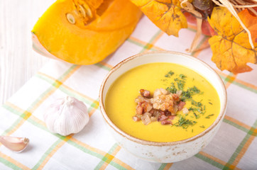 Bowl of pumpkin soup with fried onion and bacon