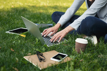 Young pensive woman using laptop in park