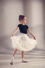 The little balerina dancer on gray background