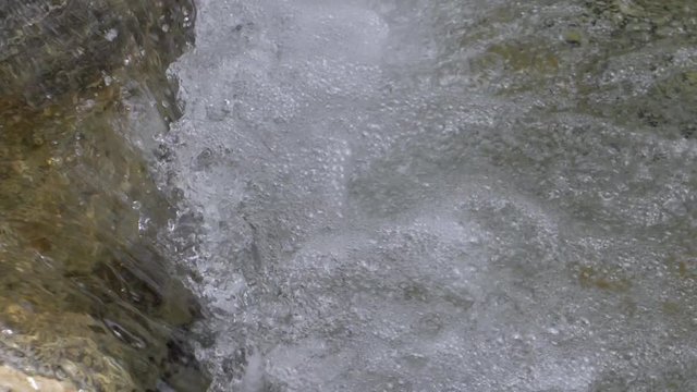 Beautiful water in a mountain river in slow motion video. Shooting speed 180fps, slow motion. Live shooting of the most beautiful nature river mountain water. The camera is not static.