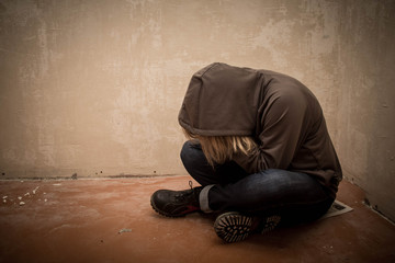 Portrait of man sad, drug addict man sitting on the floor in corner