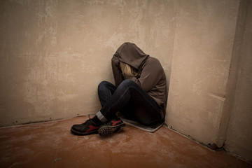 Portrait of man sad, drug addict man sitting on the floor in corner - obrazy, fototapety, plakaty