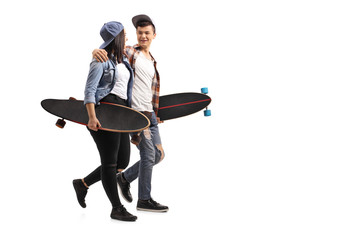 Teenage skaters with longboards talking with each other and walking