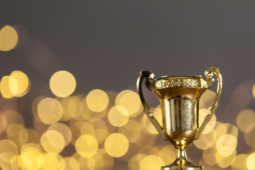 Gold award trophy against bright blurred lights