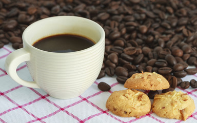 Cup Of Coffee With Cookies And Roasted Coffee Beans On Table In Morning.