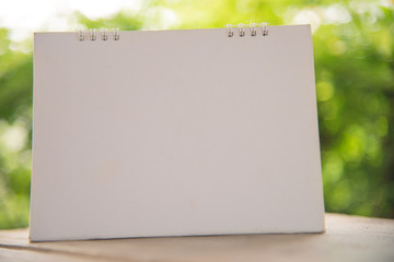 white calendar on green blur background.