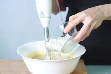 Mujer haciendo un postre casero con batidora