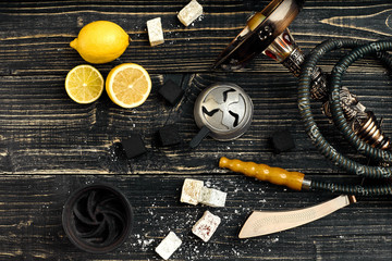 Dismantled parts of hookah on a wooden background with lemon fru