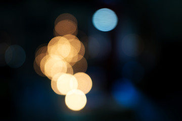 the bokeh of the candles yellow lights on a dark blue background