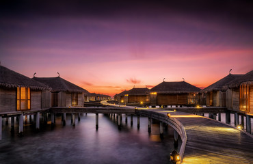 Sonnenuntergang hinter Wasser Bungalows auf den Malediven