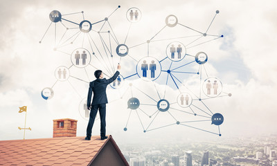 Businessman on house roof presenting networking and connection c