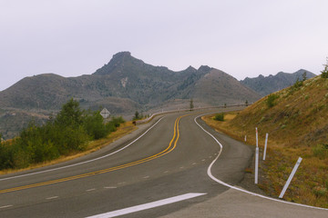 Empty road in mountain landscape on cloudy day in Washington, USA