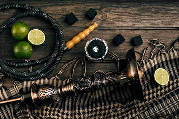 Dismantled parts of hookah on a wooden background with lime frui