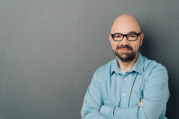 Thoughtful bald businessman in blue shirt