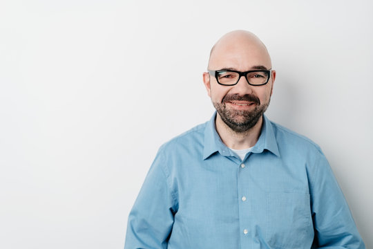 Smiling middle aged bald man in glasses