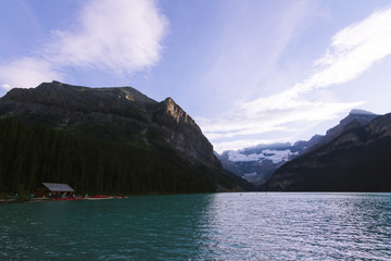 People on canoe on Lake Louise in Rocky Mountains while last light during sunset