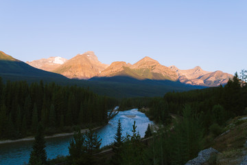 Green river and forest with big mountains in Banff near Lake Louise during sunrise