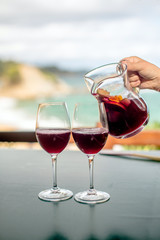 She pours the Sangria into two glasses