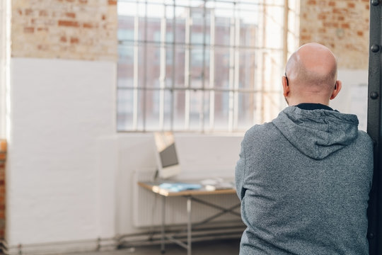 Rear view of a man wearing gray hooded sweatshirt