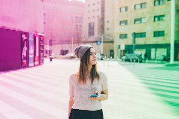 Fototapeta premium Young woman outdoor using smart phone hand hold looking away - technology, social network, phubbing concept