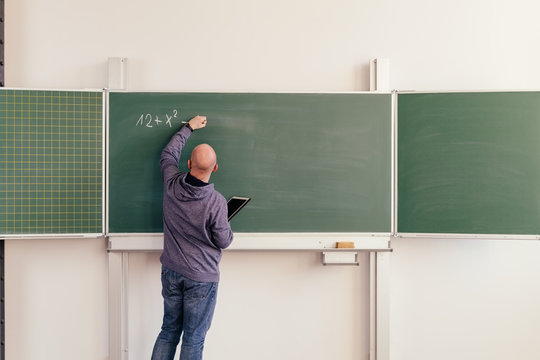 Maths teacher writing on a chalkboard