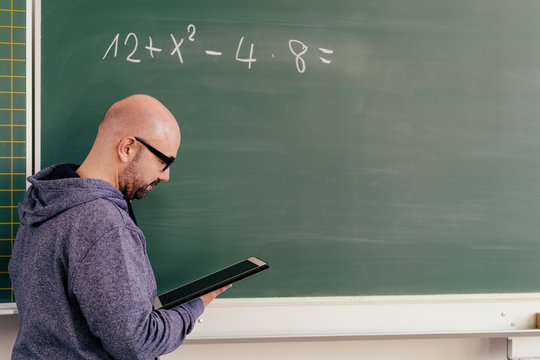 Maths teacher in front of a chalkboard