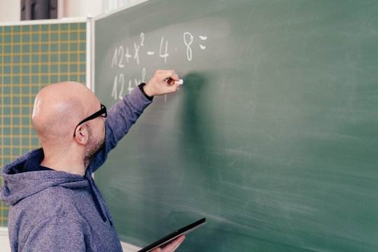 Male teacher writing a mathematical equation