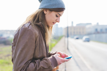 Young woman in the city using smart phone hand hold - technology, social network, phubbing concept