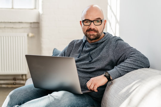 Portrait of a middle-aged man holding a laptop