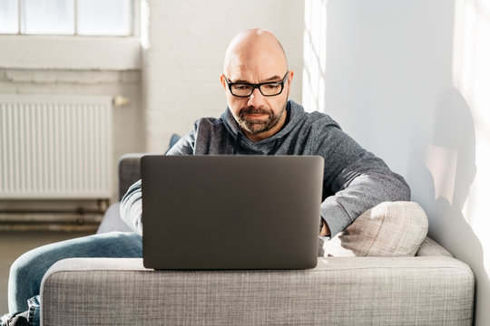 Man relaxing at home working on a laptop