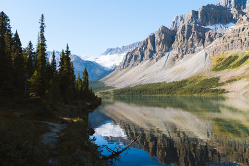 Fototapeta premium Reflection of Rocky Mountains in Bow Lake in Canada on sunny day with clear sky