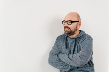 Man standing leaning against a white wall