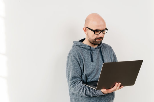 Casual man standing using a handheld laptop