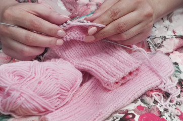 The woman knits woolen clothes.