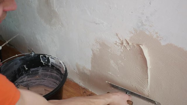 worker applies plaster to the wall