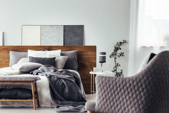 Gray armchair facing white bed