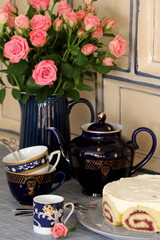 Kaffeetafel mit Porzellan in Blau und Rosenstrauß