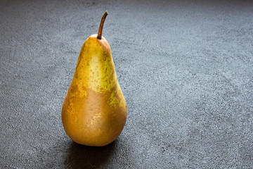 Juicy pear on a dark concrete background.