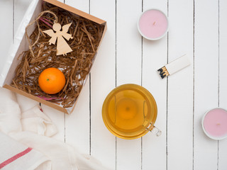 Glass cup of green tea and tangerine on a white wooden table