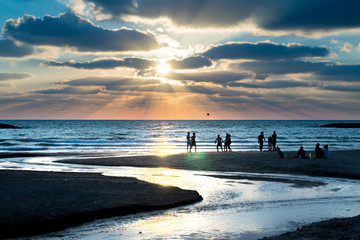 Sunset behind soccer players on the beach in Tel Aviv