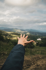Рука на фоне гор